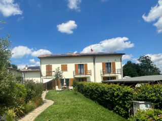 Vista frontale di un'abitazione privata bianca e del suo giardino